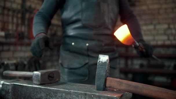 Le forgeron donne forme avec un marteau à un objet métallique rouge chaud, au ralenti — Video