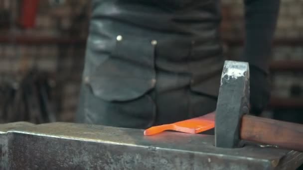 Кузнец вручную ковал расплавленный металл в кузнице — стоковое видео