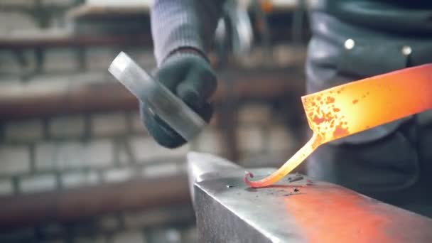El herrero moldeando el acero fundido caliente con un martillo en el yunque — Vídeo de stock
