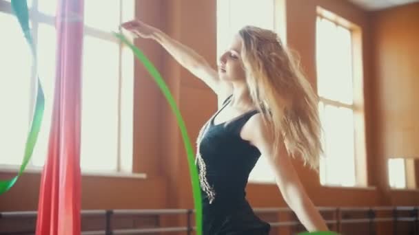 Gimnasia rítmica - mujer joven entrenando un ejercicio de gimnasia con una cinta verde, cámara lenta — Vídeo de stock
