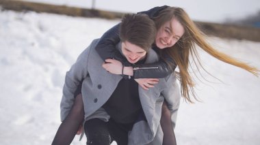 Genç adam bir taşır sırtında mutlu kız vererek