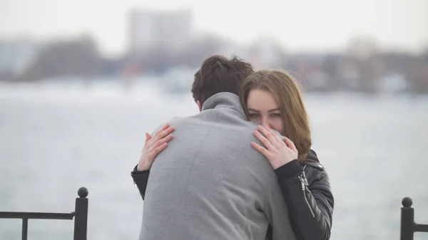 Pareja joven abrazándose en el fondo en la orilla del río —  Fotos de Stock