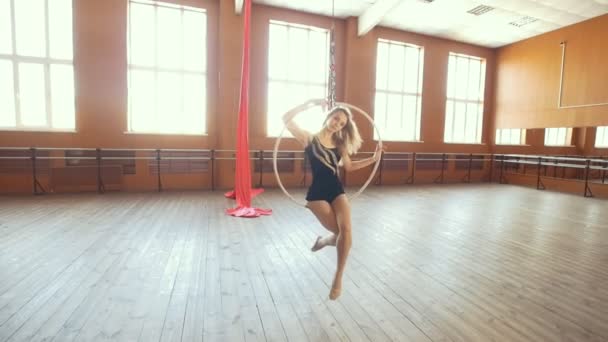 Молодая балерина, качающаяся на воздушном обруче в студии — стоковое видео