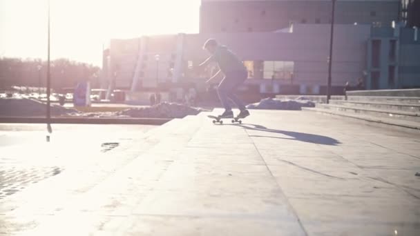 Молодой скейтбордист прыгает с лестницы под открытым небом в солнечный день — стоковое видео
