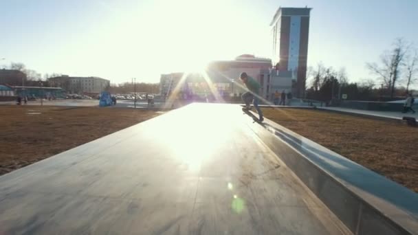 Skateboardista dělá triky na trati venku v západu slunce — Stock video