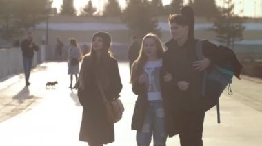 Günbatımında açık havada yürüyen genç mutlu arkadaşlar görüşmeler