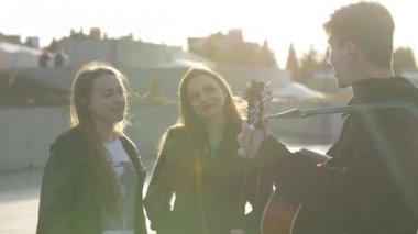 Günbatımında açık havada gitar çalmaya adamla şarkı arkadaşlar