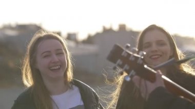 Üç arkadaş ile gitar günbatımında açık havada şarkı