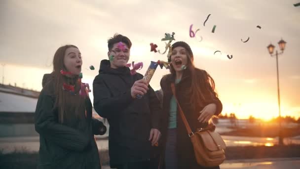 Young friends laughing and having fun with confetti outdoors — Stock Video