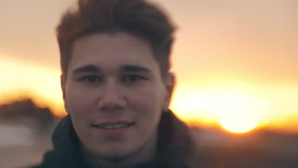 Portret van Kaukasische Glimlachende man bij zonsondergang buitenshuis — Stockvideo