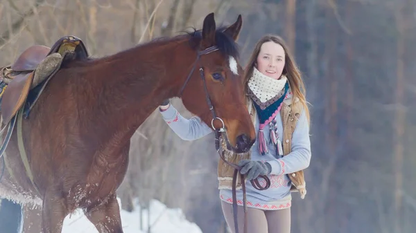 Portrét krásné ženy jezdec a černého koně v zimě oboru — Stock fotografie