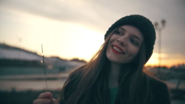 Jovem atraente com sparkler ao pôr do sol ao ar livre — Vídeo de Stock