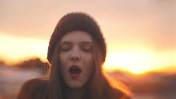 Портрет молодой женщины, развлекающейся на закате на открытом воздухе — стоковое видео