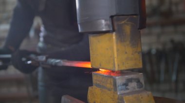 Erimiş metal bir demirci elinde baskı altında işlenir