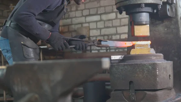 Uomo fabbro forgia il metallo al martello meccanico — Foto Stock