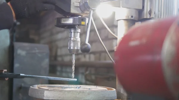 Workshop werknemer boren van een metalen plaat met een boor maschine — Stockfoto