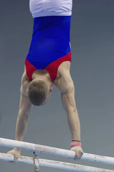 Задний вид мускулистых мужчин гимнастов, соревнующихся на стойке — стоковое фото