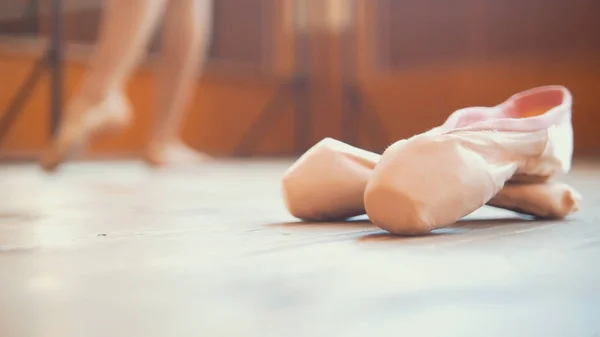 Primer plano de un zapato de bailarinas de ballet delante de una chica —  Fotos de Stock