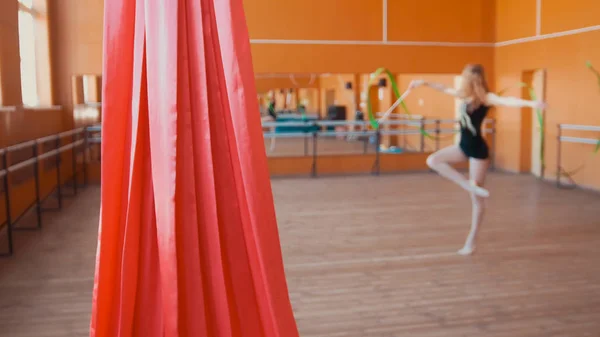 Seda vermelha na frente da jovem treinando um exercício de ginástica com uma fita — Fotografia de Stock
