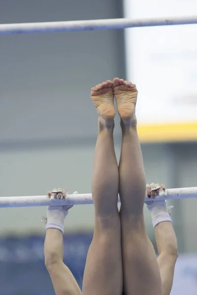 Benen opknoping op de dwarsbalk van de atletische vrouw — Stockfoto