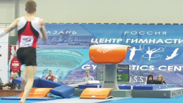 KAZAN, RUSIA - 18 DE ABRIL DE 2018: El campeonato de gimnasia deportiva - atleta masculino que realiza un salto en el campeonato — Vídeo de stock