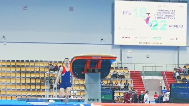Kazan, Rusko - 18 dubna 2018: Mladý sportovní mužské gymnastka provádí skok na soutěži — Stock video