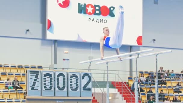 Kazan, Rusland - April 18, 2018: Russische Turnen championship - jonge mannelijke atleet uitvoeren op ongelijke liggers — Stockvideo