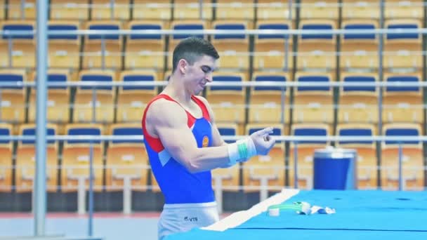 KAZAN, RÚSSIA - 18 de abril de 2018: Campeonato Russo de Ginástica - Ginasta masculino gravando as mãos em preparação para a competição — Vídeo de Stock