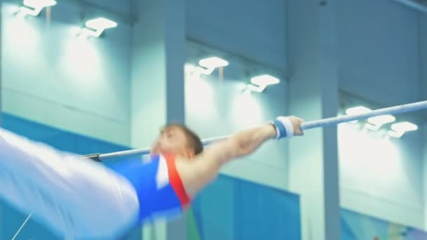 KAZAN, RUSIA - 18 DE ABRIL DE 2018: Campeonato de Gimnasia de toda Rusia - Atlético gimnasta masculino saltando en la barra — Vídeos de Stock