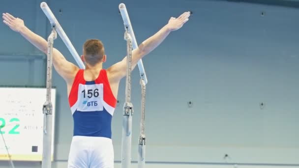 Kazan, Rusko - 18 dubna 2018: All-ruské mistrovství gymnastika - mužské sportovní gymnastka dělá skok na nerovnoměrné bar — Stock video