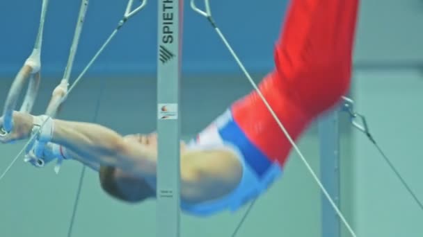КАЗАН, РОССИЯ - 18 апреля 2018 года: Всероссийский чемпионат по гимнастике - мускулистый спортсмен кружится на гимнастических кольцах — стоковое видео
