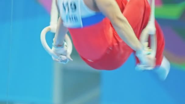 Kazan, Rusko - 18 dubna 2018: All-ruské gymnastiky mistrovství - svalnatý mladý sportovec na gymnastické kruhy — Stock video