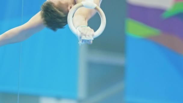 Kazan, Rusland - April 18, 2018: Russische Turnen championship - gespierde jonge atleet uitvoeren van een sprong van gymnastiek ringen — Stockvideo