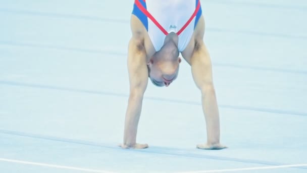 KAZAN, RUSIA - 18 DE ABRIL DE 2018: Campeonato de Gimnasia All-Russian - Muscular masculino gimnasta realizando un handstand — Vídeo de stock