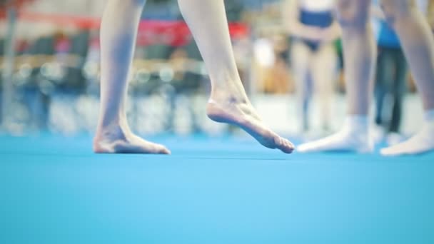 Pies de mujer joven gimnasta compitiendo en el estadio — Vídeo de stock