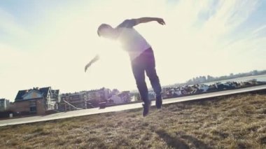 Genç erkek Parkour şaşırtıcı tricker jumper gerçekleştirir çevirir, siluet