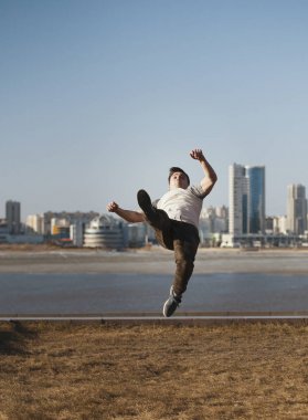 Genç erkek Parkour sporcu siluetinin önünde akrobasi atlar gerçekleştirir