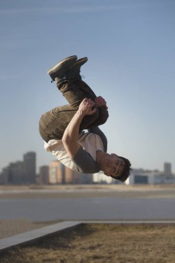 Genç adam Parkour sporcu siluetinin önünde hileler gerçekleştirir