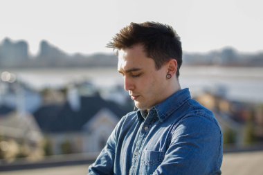Şehir manzarası önünde genç adam portresi