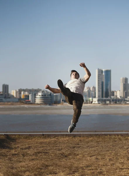 Молодий чоловічий спортсмен паркур виконує акробатичні стрибки перед горизонтом — стокове фото