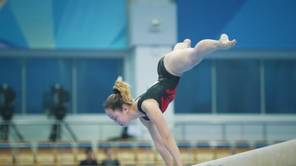 KAZAN, RUSIA - 18 DE ABRIL DE 2018: Campeonato de Gimnasia All-Russian - Gimnasta femenina flexible que actúa en el estadio — Vídeo de stock