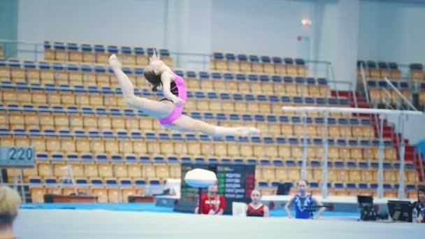 КАЗАН, РОССИЯ - 18 апреля 2018 года: Всероссийский чемпионат по гимнастике - девушка-гимнастка в розовом костюме выполняет трюки на чемпионате — стоковое видео