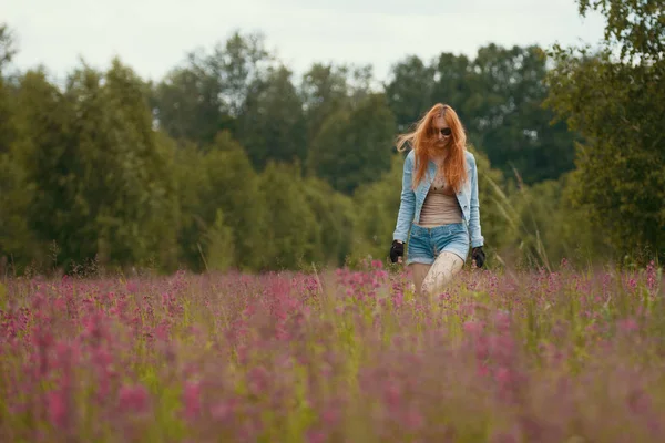 Привлекательная сексуальная женщина в спортивной одежде в поле с цветами — стоковое фото