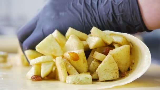 Köchin bereitet frischen Apfel im Teig für Kuchenstrudel zu — Stockvideo