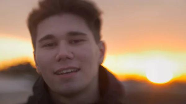 Retrato de jovem atraente homem sorrindo ao pôr do sol — Fotografia de Stock