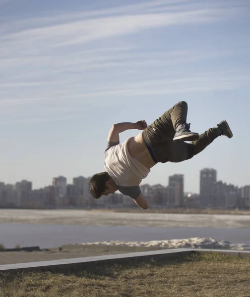 Młody człowiek parkour sportowcem wykonuje sztuczki przed Skyline — Zdjęcie stockowe