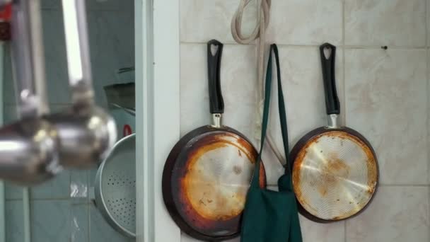 Planchas y espumaderas colgando en el soporte en la cocina del restaurante — Vídeo de stock