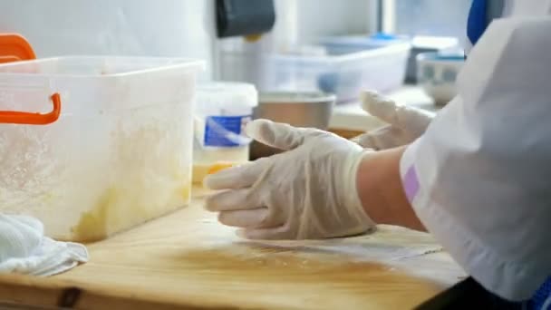 Hands of baker kneading dough in gloves — Stock Video