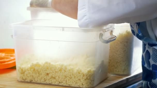 Mani di panettiere mette il formaggio nel contenitore — Video Stock