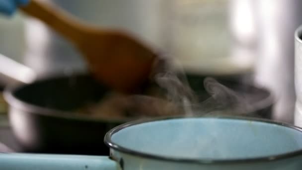 Köksmästaren blandar mat framför ångpanna — Stockvideo